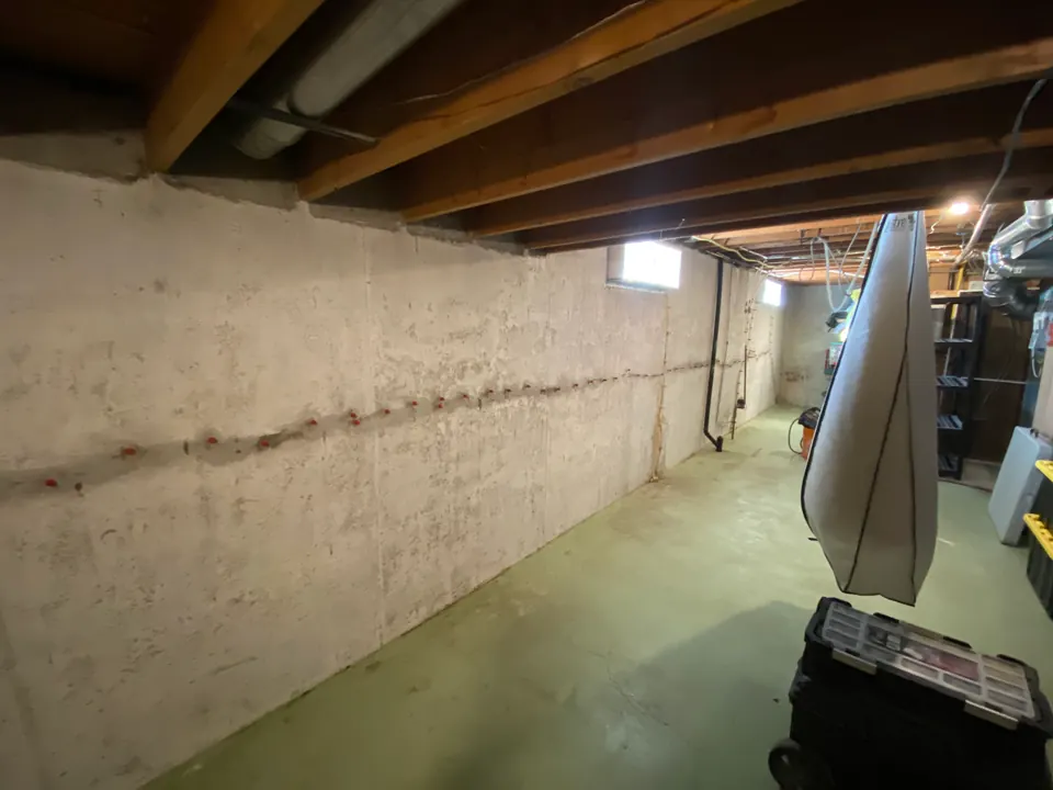 Wide view of a basement with a horizontal treated line across the concrete wall