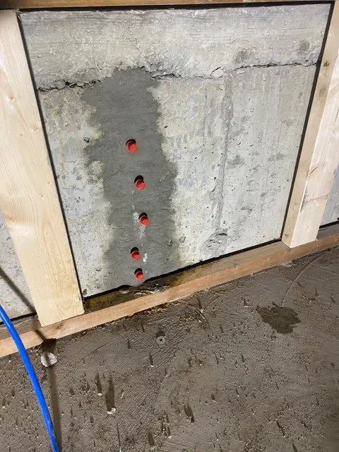 Red repair ports along a prepared vertical crack inside an opened wall panel